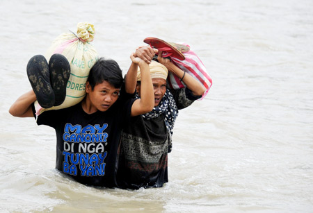 Người dân tại Iligan vượt sông để lấy hàng cứu trợ .
